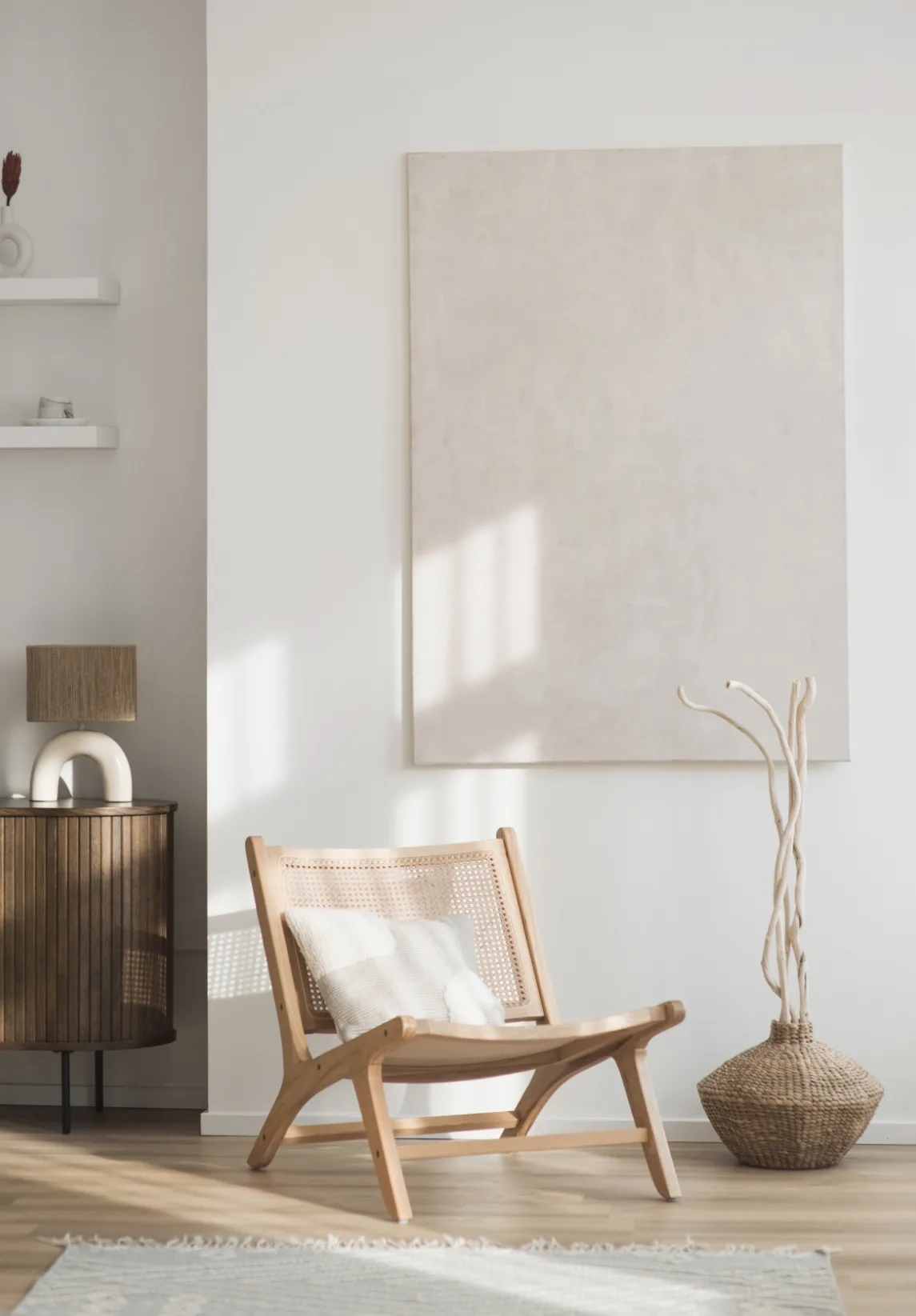 Rincón con butaca de madera y ratán bañado por luz natural